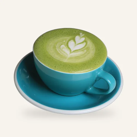 Matcha latte with latte art in a teal cup