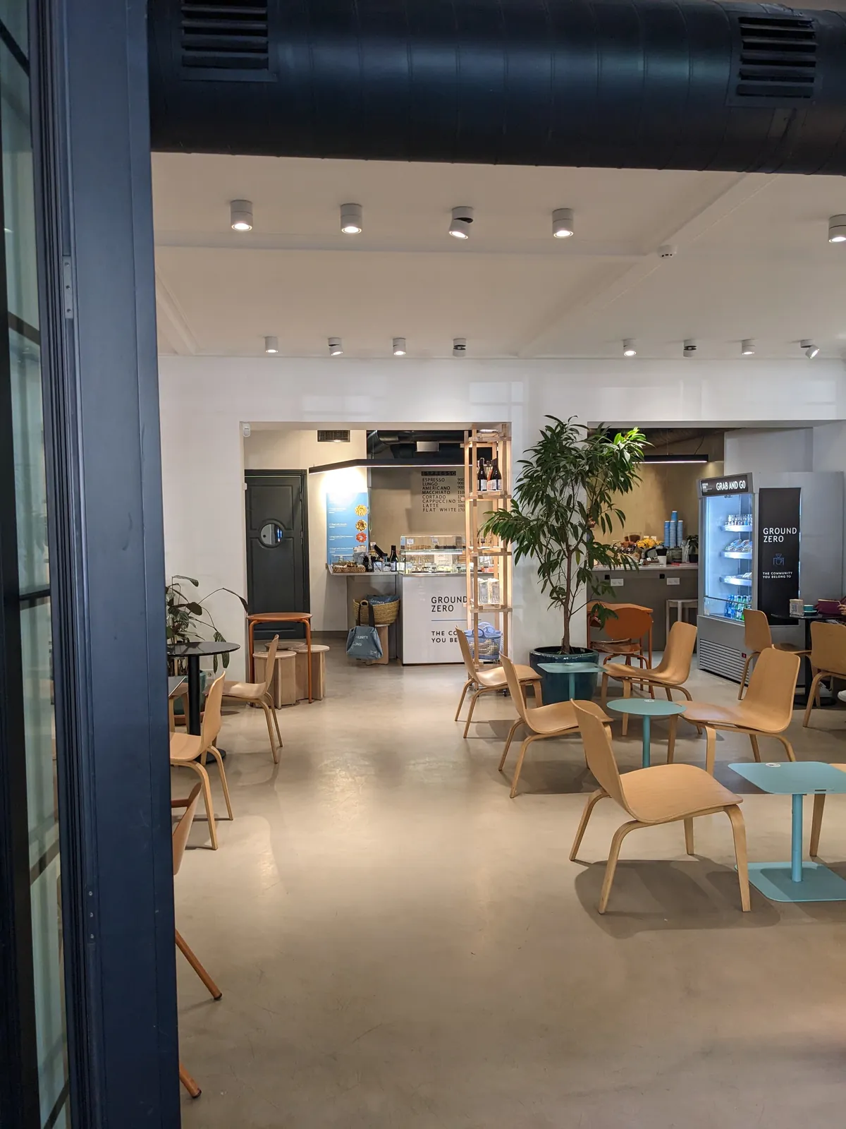 Bright white hall with plywood chairs and an orange table