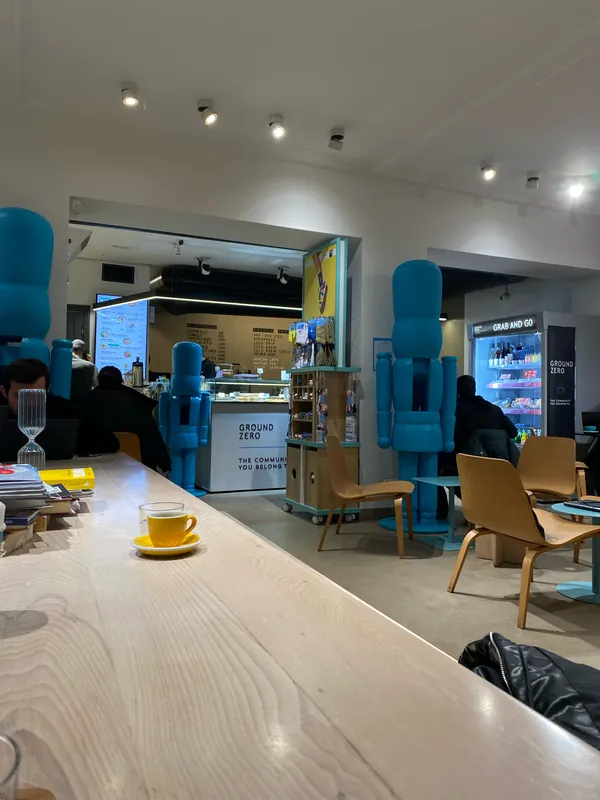 Long wooden table with a yellow cup, blue figures by the counter